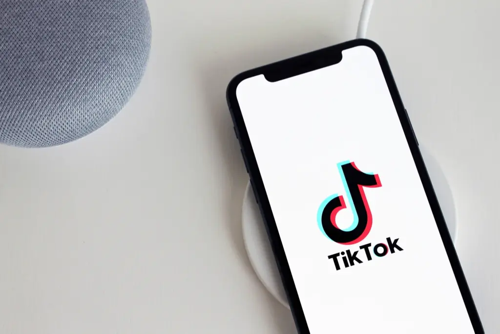 TikTok auf einem Smartphone, welches gerade kabellos aufgeladen wird.